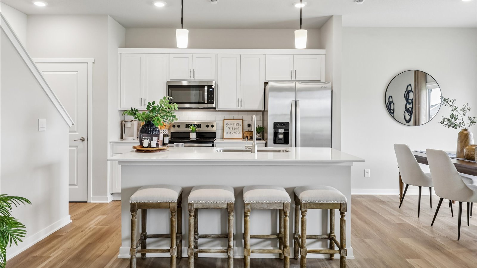 Open kitchen with white cabinetry and island seating